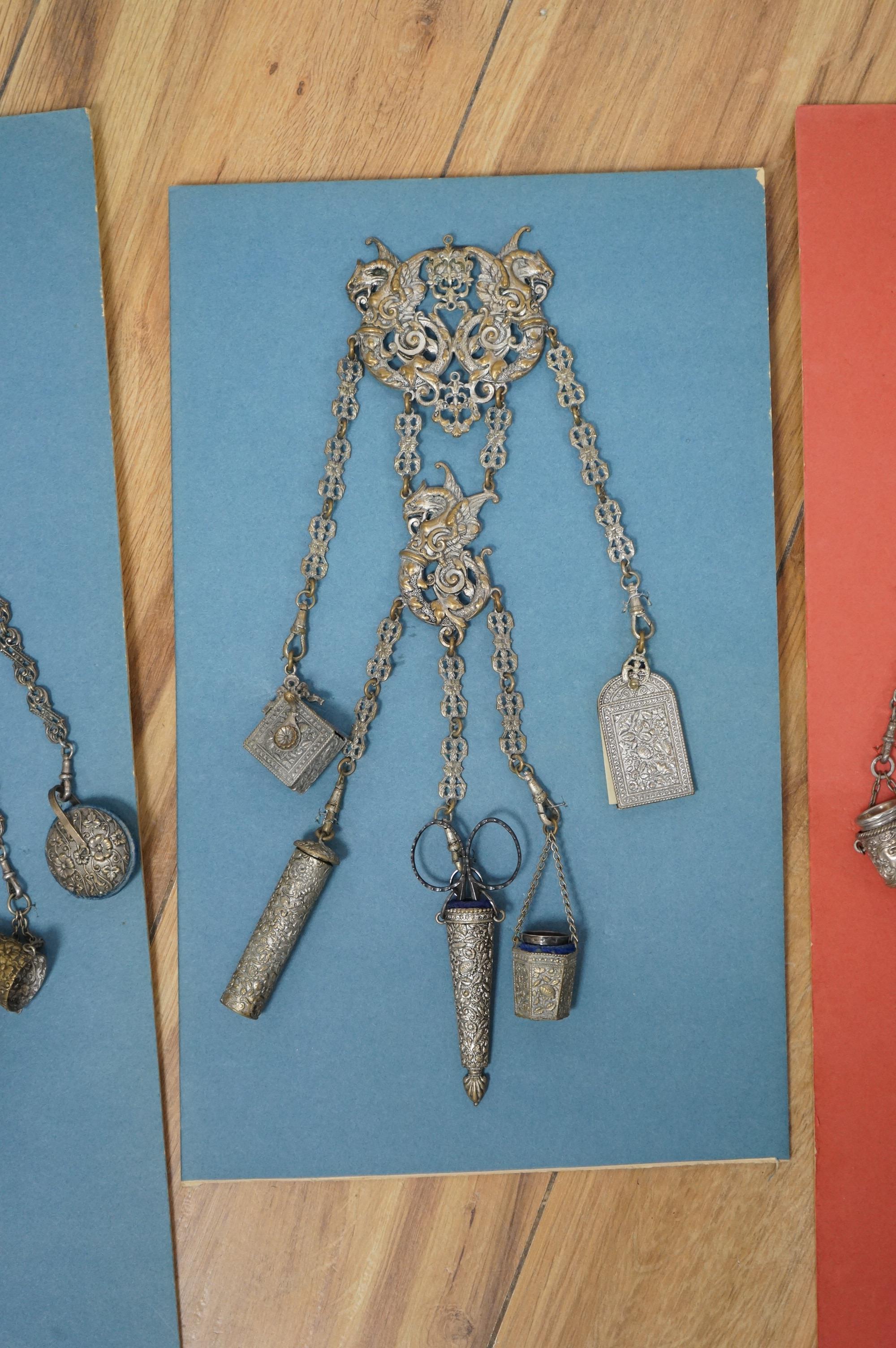 Four assorted 19th century base metal chatelaines, one with some silver implements